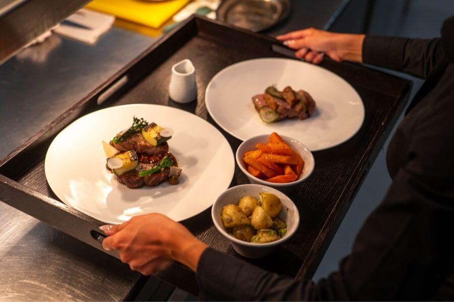 A chef at Blas Restaurant prepares fresh monkfish in the kitchen, showcasing carefully sourced seafood featured on the 2026 Summer Menu.