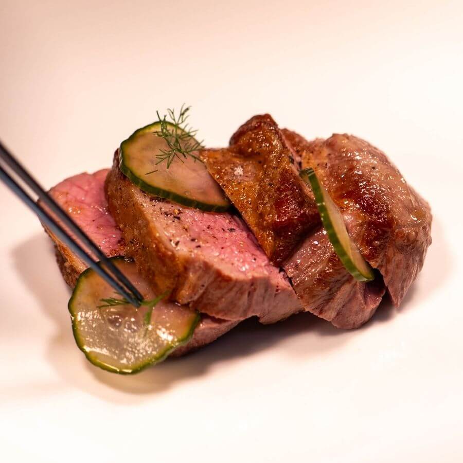 Blas Restaurant chefs carefully preparing a seasonal lamb dish in the kitchen, highlighting fresh ingredients and refined Welsh cuisine from the 2026 Summer Menu.